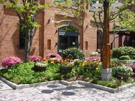 Restored tobacco warehouses with landscaping and trees in front.