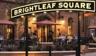 Large, arched "Brightleaf Square" sign at night.