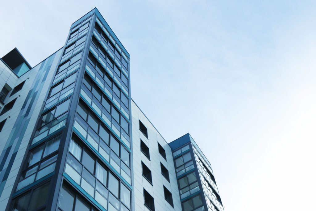 View of tall apartment complex against clear skies.